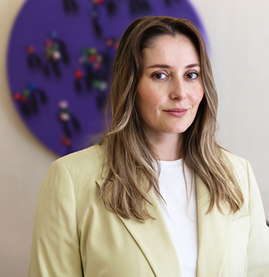 Açık renkli blazer giymiş bir kadın, nötr arka plan.